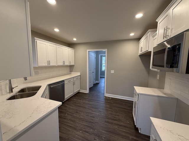 kitchen with sink, tasteful backsplash, light stone counters, white cabinets, and appliances with stainless steel finishes