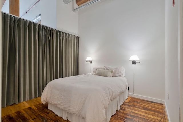 bedroom featuring hardwood / wood-style floors and baseboards