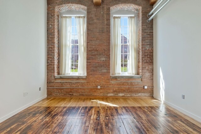 unfurnished room featuring hardwood / wood-style flooring and baseboards