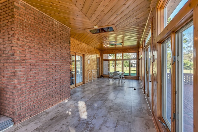 unfurnished sunroom with wood ceiling and a skylight