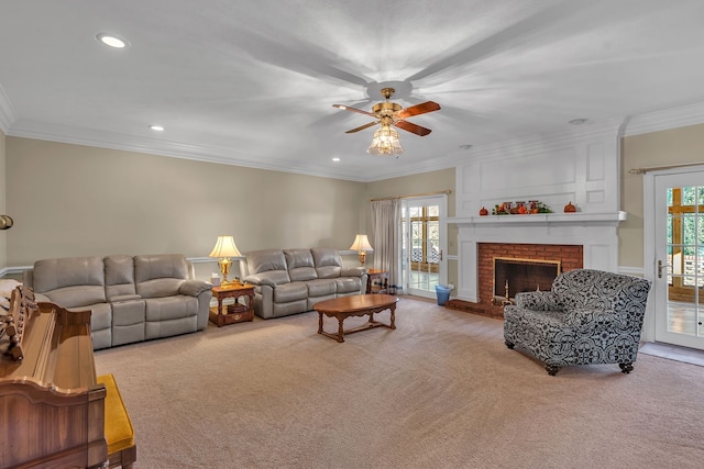 carpeted living room featuring a fireplace, ceiling fan, and ornamental molding