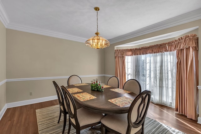 dining room featuring an inviting chandelier, crown molding, and dark wood-type flooring