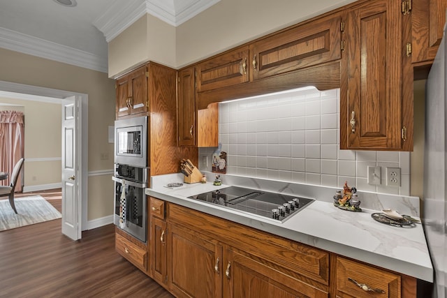 kitchen with backsplash, stainless steel appliances, dark hardwood / wood-style floors, and ornamental molding