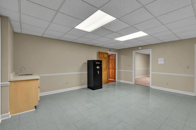 basement featuring a drop ceiling and sink