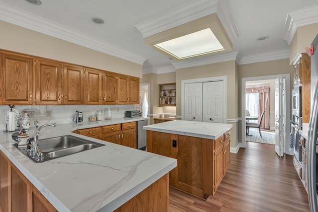 kitchen featuring hardwood / wood-style flooring, a kitchen island, ornamental molding, and sink