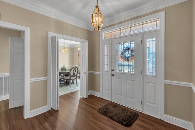 foyer entrance featuring dark hardwood / wood-style flooring, an inviting chandelier, and ornamental molding