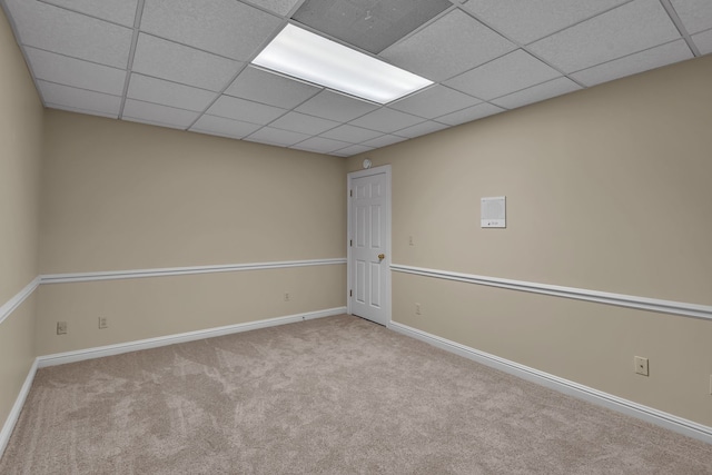 carpeted empty room featuring a drop ceiling