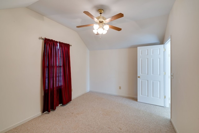 interior space with ceiling fan, light colored carpet, and vaulted ceiling