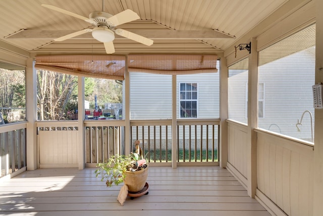 sunroom / solarium with ceiling fan, lofted ceiling with beams, and wood ceiling