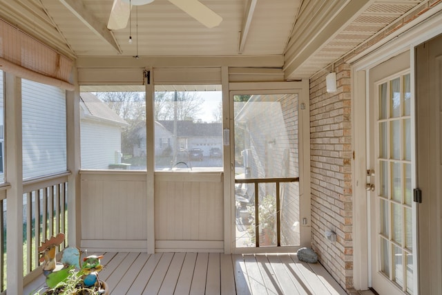 unfurnished sunroom featuring vaulted ceiling with beams and ceiling fan