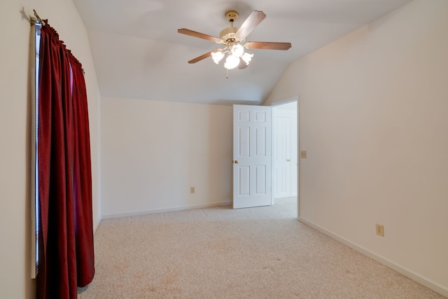 carpeted spare room featuring ceiling fan and lofted ceiling