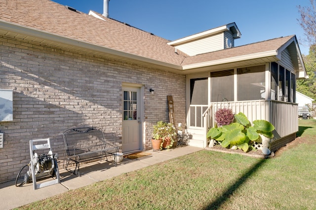 back of house with a sunroom and a lawn