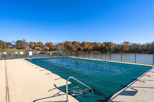 view of pool with a water view and a patio