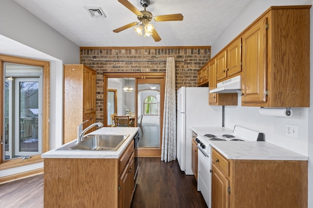 kitchen with brick wall, a textured ceiling, white range oven, dark wood-type flooring, and sink