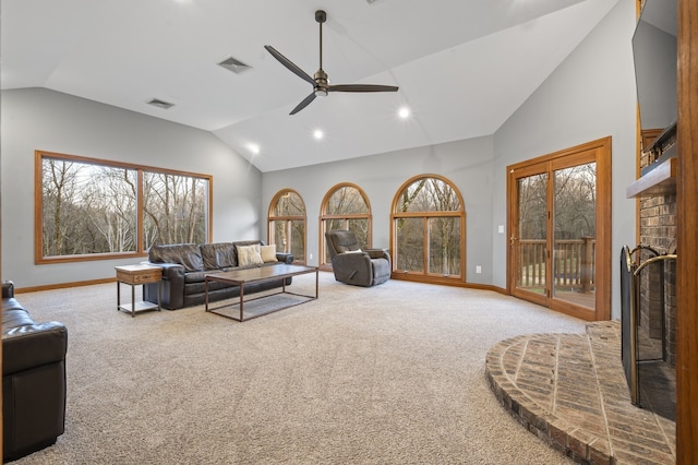 carpeted living room featuring ceiling fan, a fireplace, and high vaulted ceiling