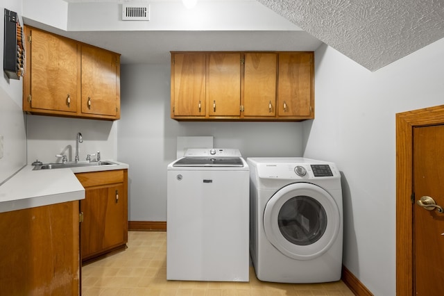 laundry area featuring washer and clothes dryer, sink, and cabinets