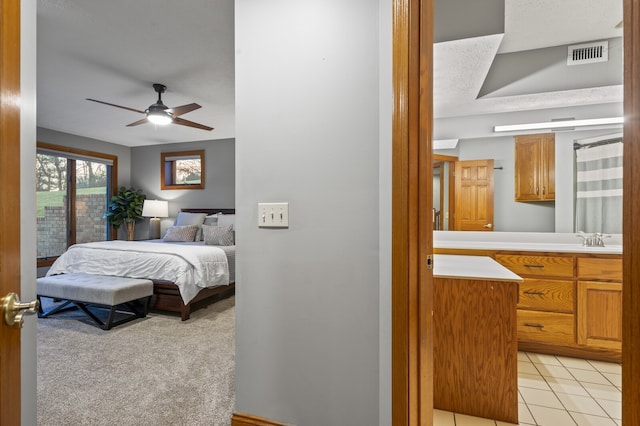 carpeted bedroom featuring ceiling fan and a textured ceiling