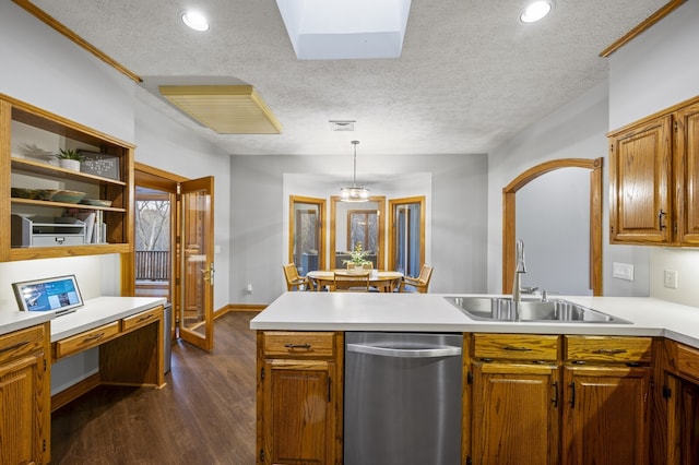 kitchen featuring dishwasher, sink, dark hardwood / wood-style floors, a textured ceiling, and decorative light fixtures