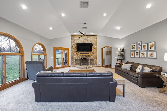 carpeted living room featuring ceiling fan, lofted ceiling, a fireplace, and a wealth of natural light