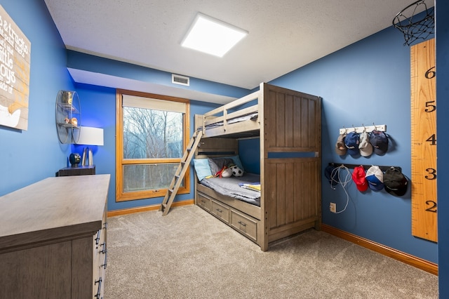 bedroom with carpet floors and a textured ceiling