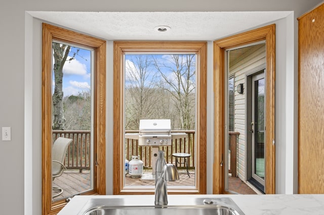 entryway with sink and a textured ceiling