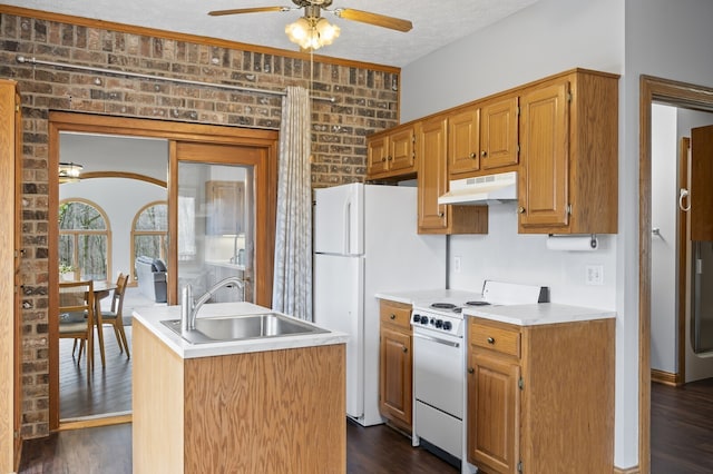 kitchen featuring brick wall, a textured ceiling, white appliances, sink, and dark hardwood / wood-style floors