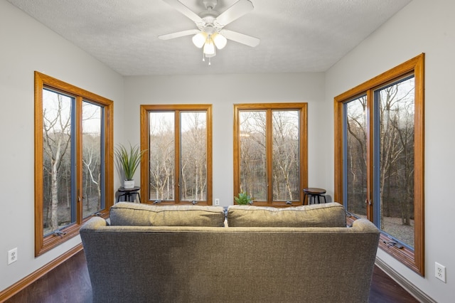 unfurnished living room with a textured ceiling, ceiling fan, and dark wood-type flooring