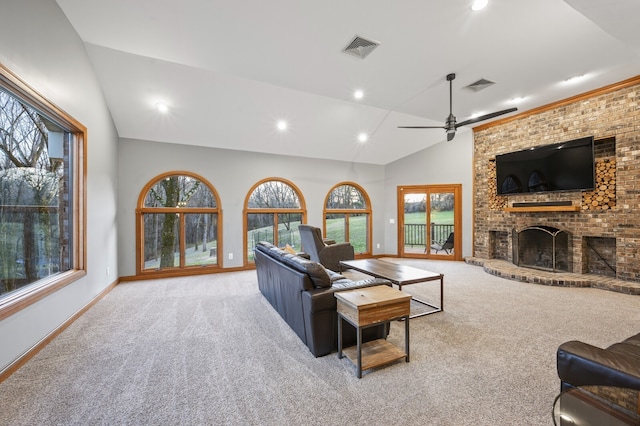 carpeted living room with a fireplace, high vaulted ceiling, ceiling fan, and a healthy amount of sunlight