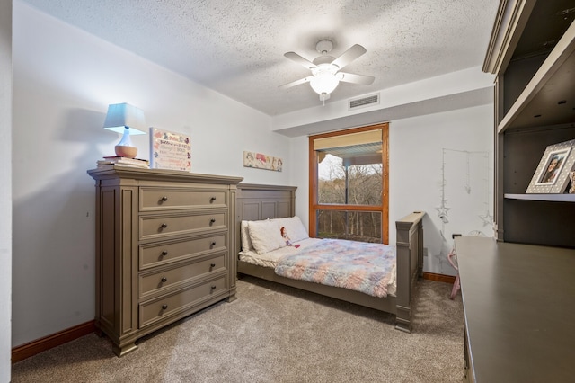 bedroom with ceiling fan, light colored carpet, and a textured ceiling