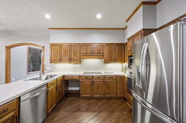 kitchen featuring appliances with stainless steel finishes, dark hardwood / wood-style flooring, a textured ceiling, crown molding, and sink