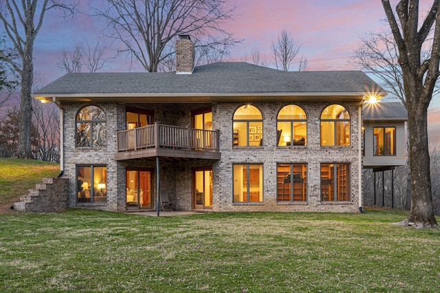 back house at dusk featuring a yard and a patio area