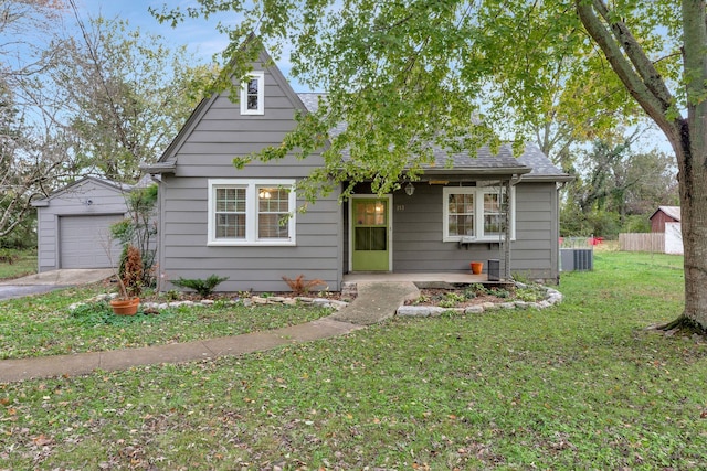 view of front of house featuring a garage, an outdoor structure, and a front lawn