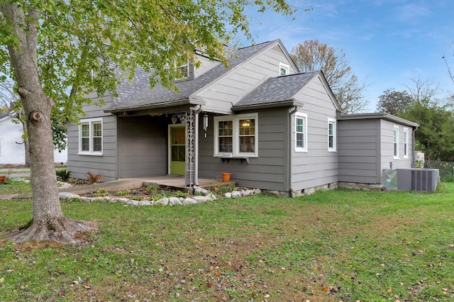 view of front facade featuring cooling unit, a patio, and a front lawn