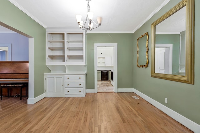 unfurnished dining area featuring an inviting chandelier, light hardwood / wood-style floors, and ornamental molding