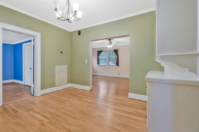 unfurnished dining area featuring ceiling fan with notable chandelier, light hardwood / wood-style flooring, and crown molding