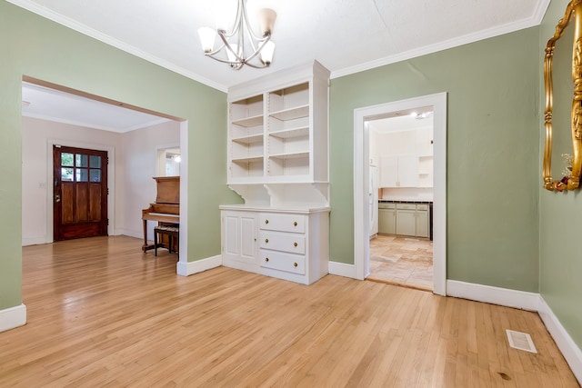 interior space with light wood-type flooring, an inviting chandelier, and ornamental molding