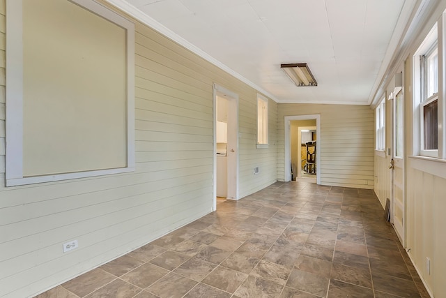 interior space featuring ornamental molding and wooden walls