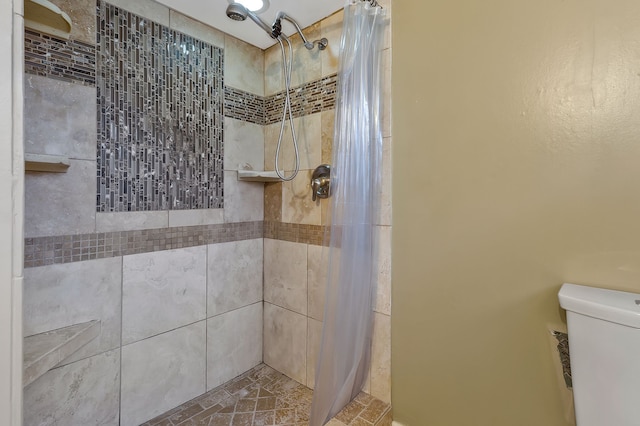 bathroom with a shower with shower curtain and toilet