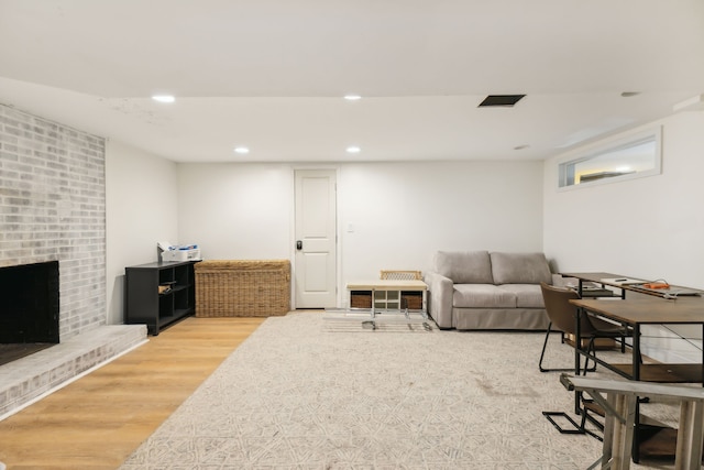 living room with a fireplace and wood-type flooring