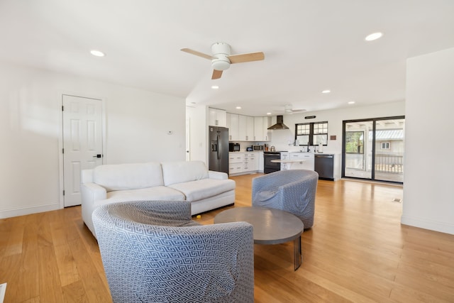 living room with ceiling fan and light hardwood / wood-style floors