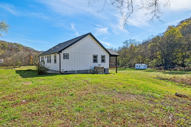 view of property exterior with a yard and a shed