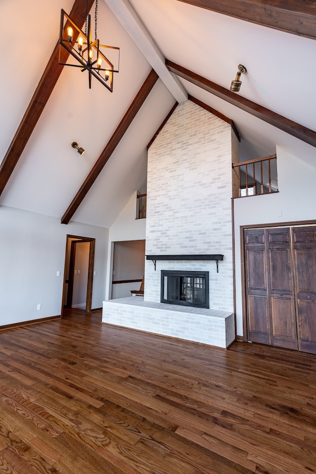 unfurnished living room featuring beam ceiling, dark hardwood / wood-style floors, high vaulted ceiling, and a brick fireplace