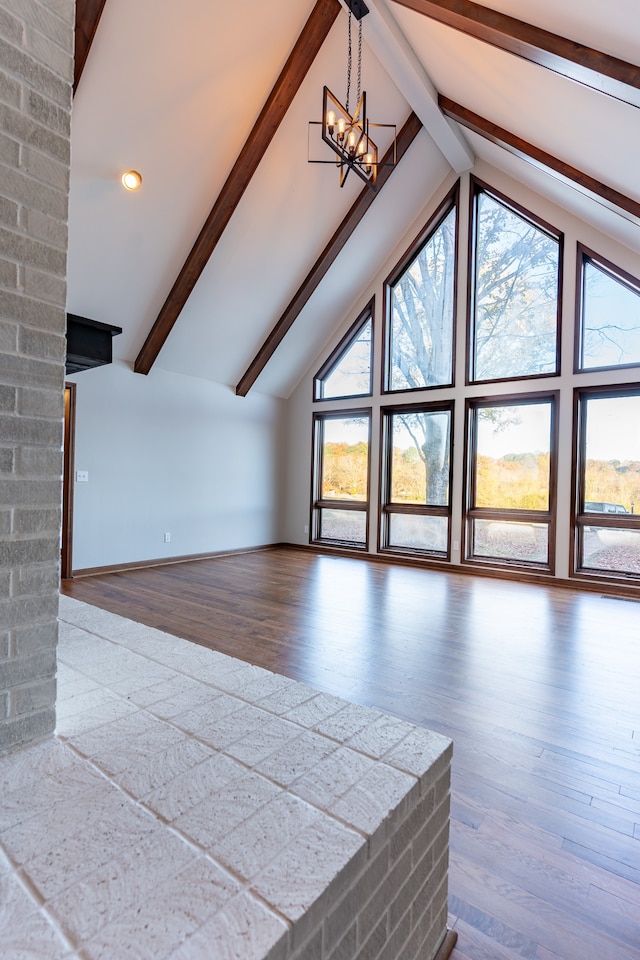 unfurnished living room featuring plenty of natural light, a notable chandelier, and hardwood / wood-style flooring