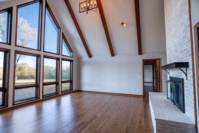 unfurnished living room featuring a brick fireplace, dark hardwood / wood-style floors, high vaulted ceiling, and plenty of natural light