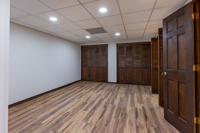 unfurnished bedroom featuring hardwood / wood-style floors and a drop ceiling