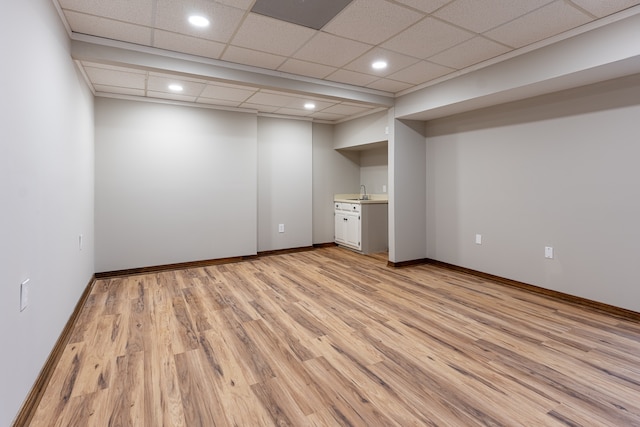 interior space featuring ensuite bathroom, light hardwood / wood-style flooring, a drop ceiling, and sink