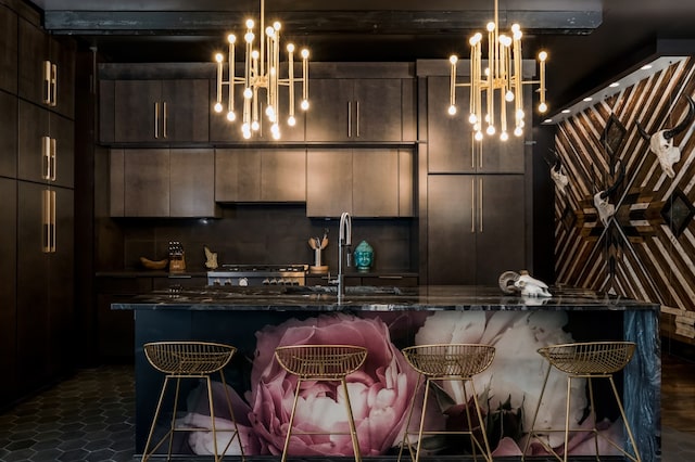 kitchen featuring a breakfast bar, hanging light fixtures, and an island with sink