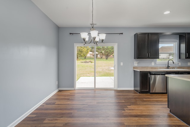 kitchen featuring dark hardwood / wood-style flooring, plenty of natural light, stainless steel dishwasher, and decorative light fixtures