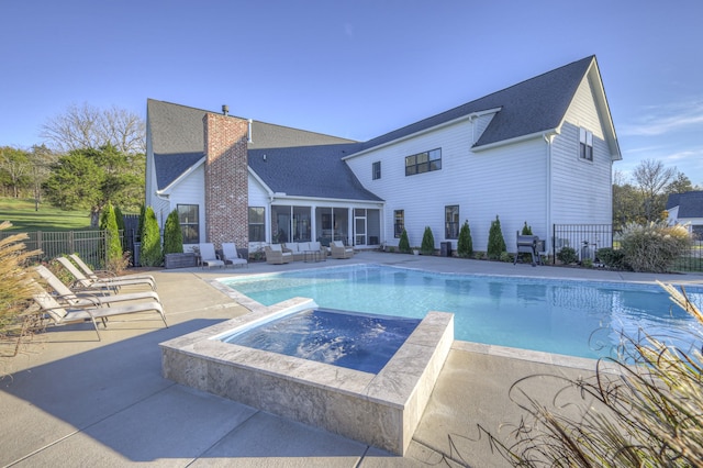 view of pool featuring outdoor lounge area, a sunroom, an in ground hot tub, and a patio