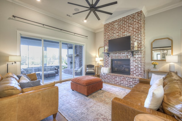 living room with a fireplace, ceiling fan, and crown molding